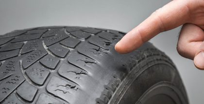 hand pointing towards car's tyre