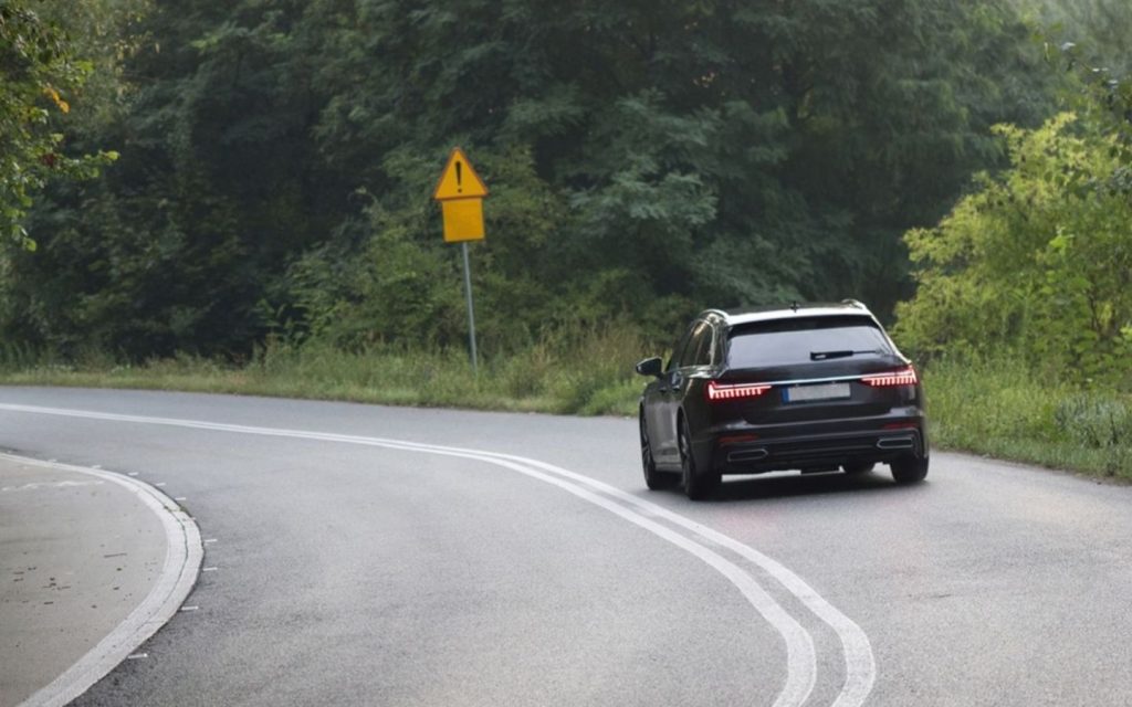 A mid-size black SUV taking a sharp turn