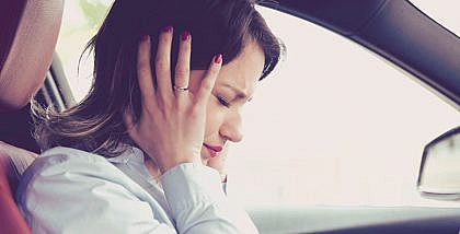 Woman covering her ears to avoid car sound