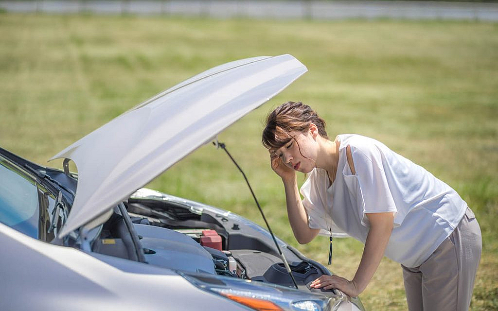 Woman hearing if her engine is making any noise