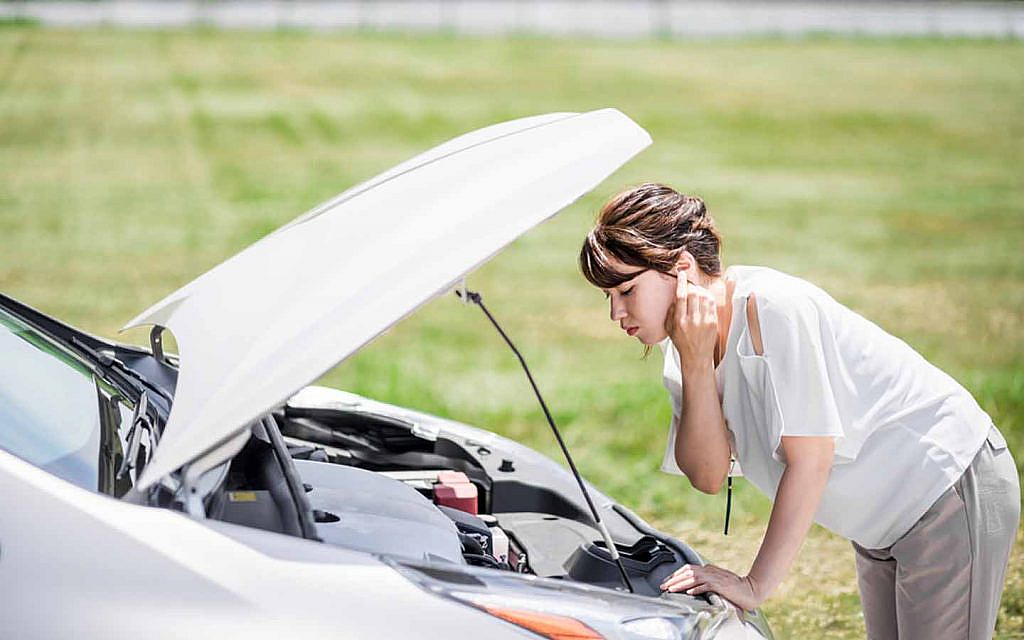 Woman checking car battery