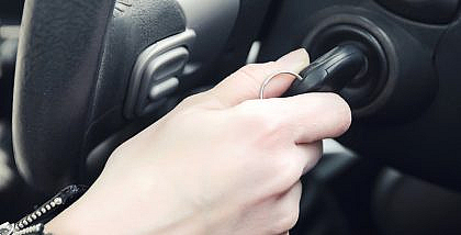 Man trying to take out car key stuck in ignition