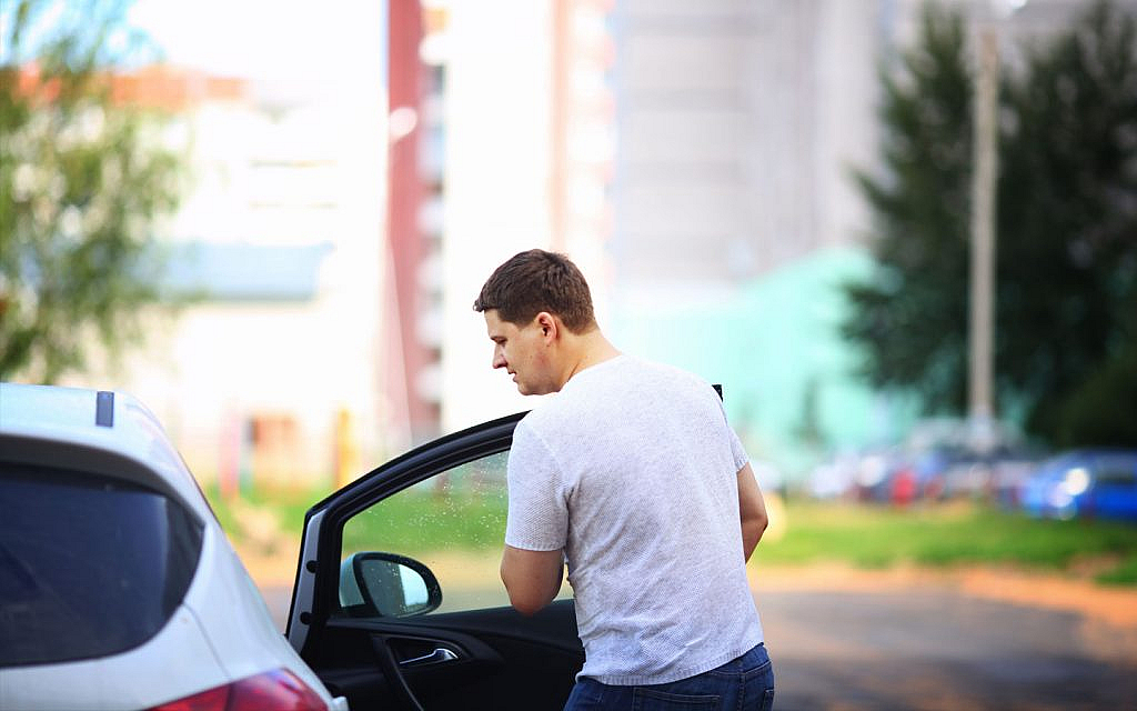 young man closes the door in the car