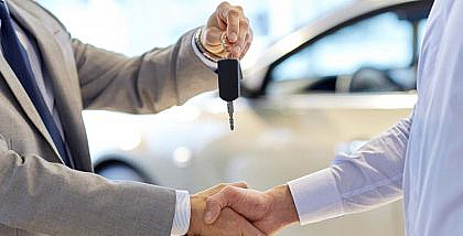 A man giving car keys to another