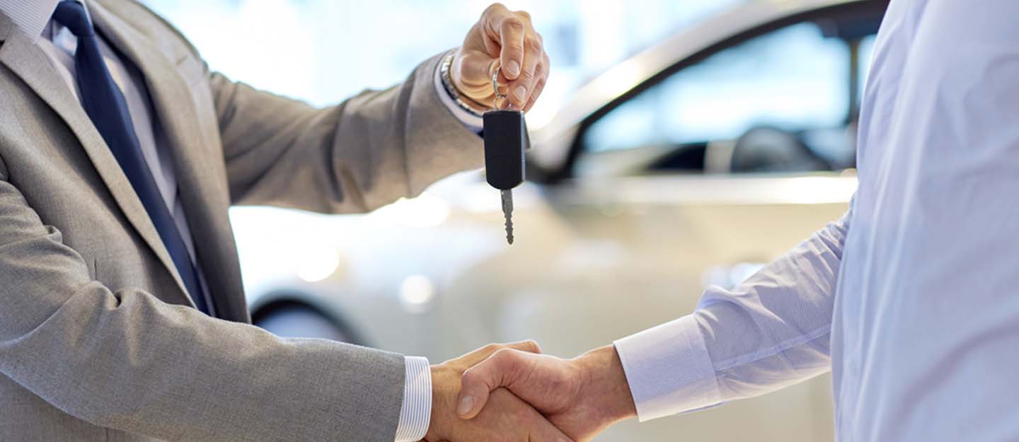 A man giving car keys to another