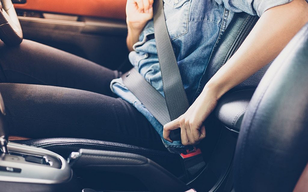 A girl fastening a seatbelt