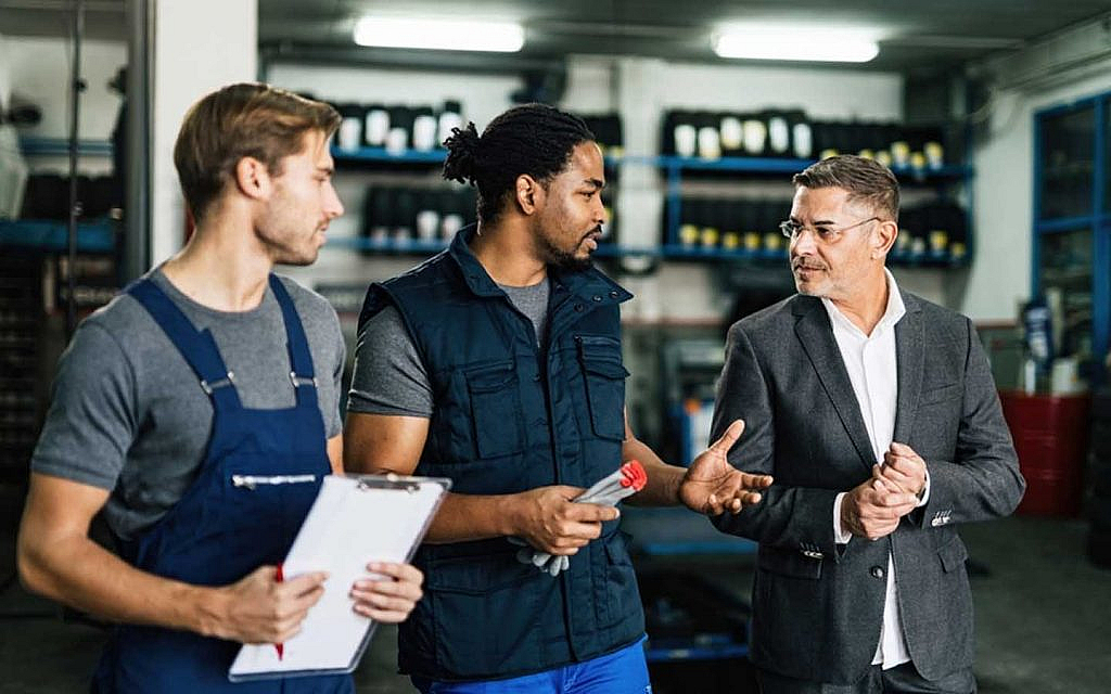 Mechanics and clients discussing auto repair rates