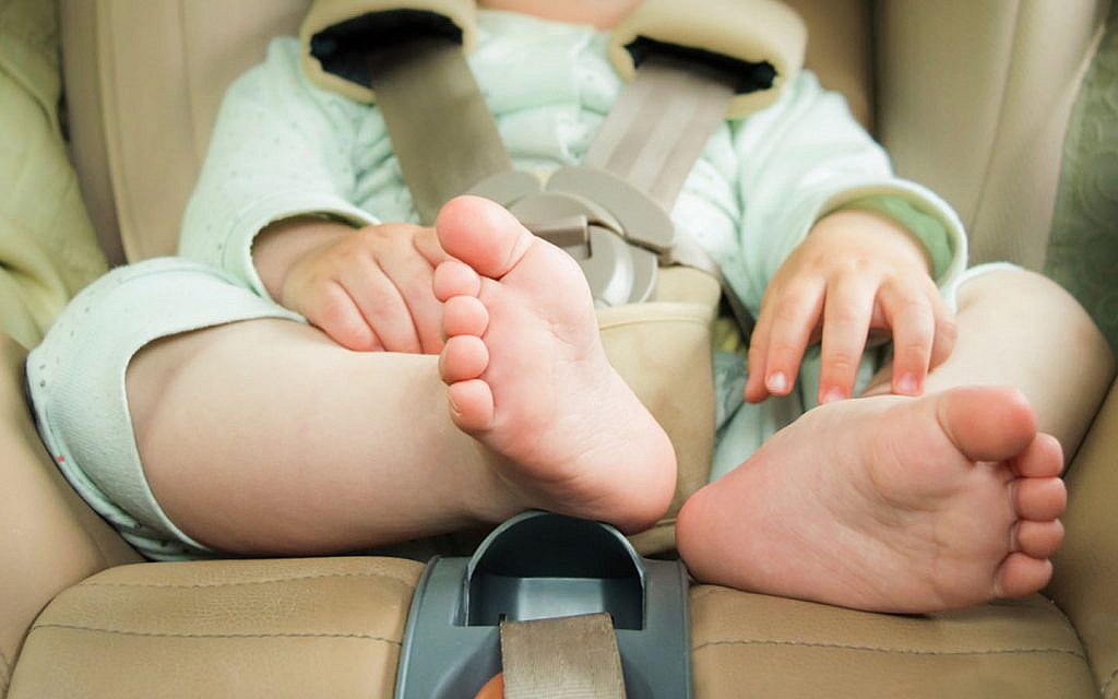 A child sitting in the back seat of a car