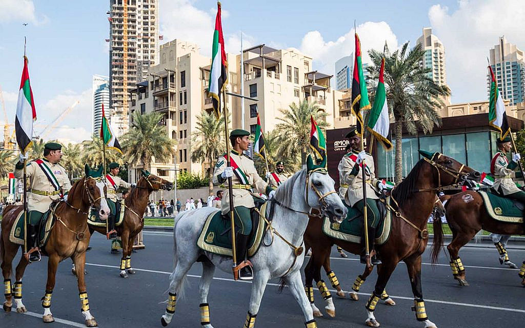 Dubai Police mounted on and riding horses at a national parade 