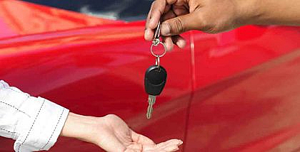 Women receiving a key from car rental owner in Dubai