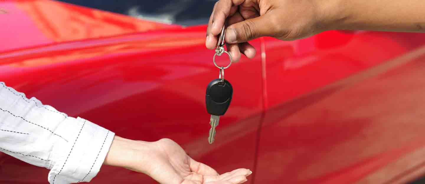 Women receiving a key from car rental owner in Dubai