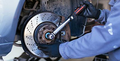 A mechanic is fixing car brakes in a garage
