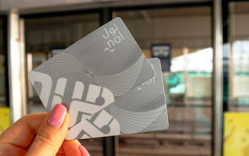 Woman holding two NOL cards while waiting for the metro 