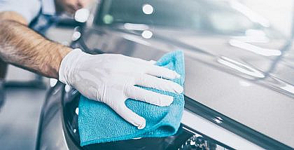 A person is cleaning a car to reduce the maintenance cost