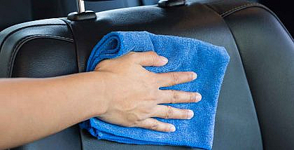 Hand cleaning car seat with a microfiber cloth