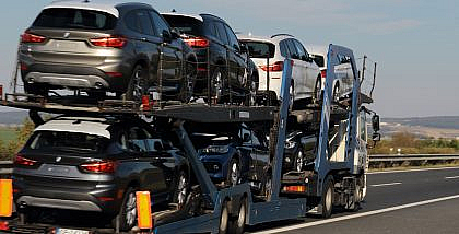 A truck carrying cars on a road