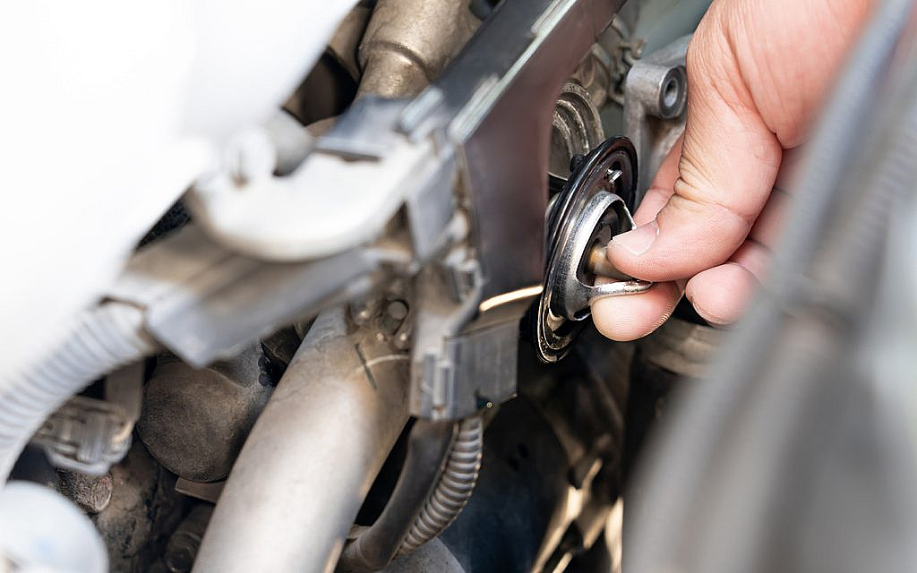 Mechanic checking reason for bad car thermostat