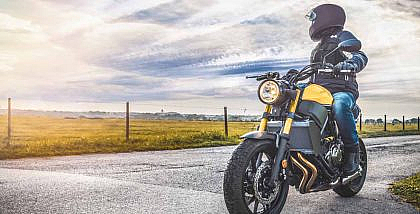A rider on a motorbike on an empty road