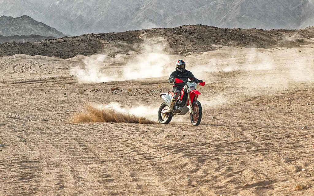 An off-road biker riding in a desert