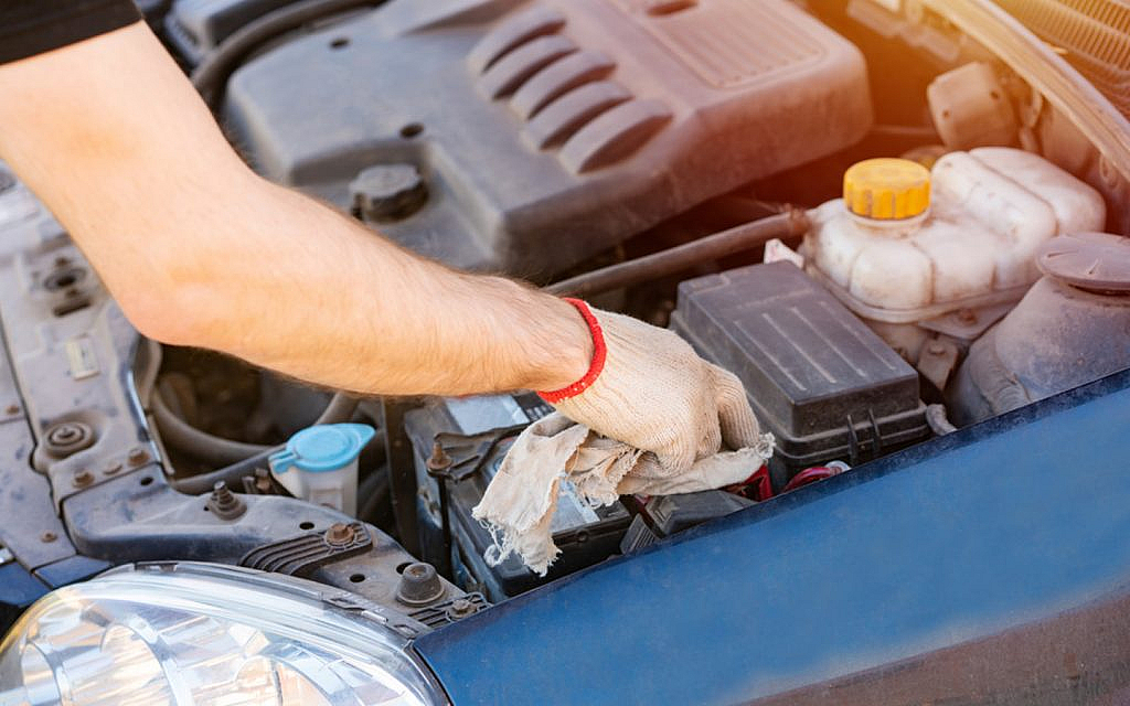 A person cleaning car battery