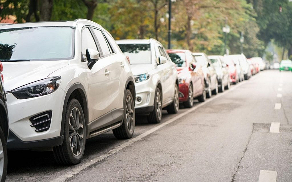 Several cars parked on a road in the city