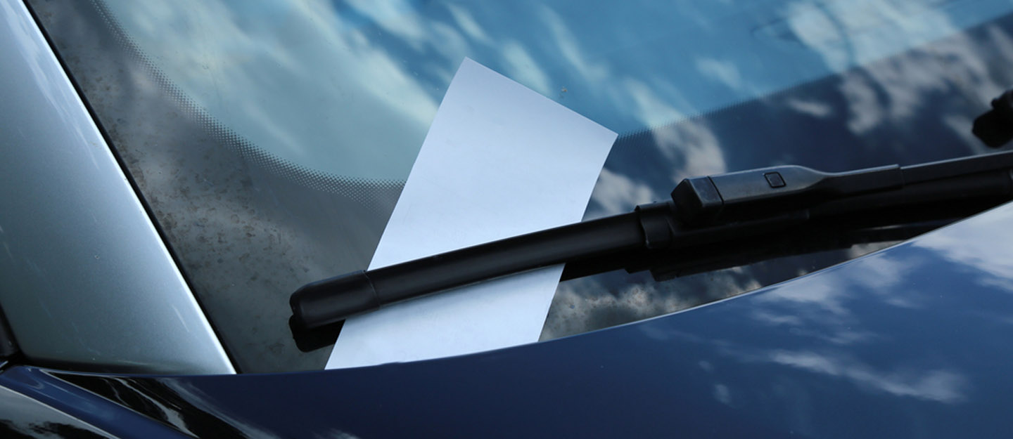 Traffic fine ticket on windshield of a car