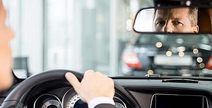 Driver looking in his car’s rearview mirror