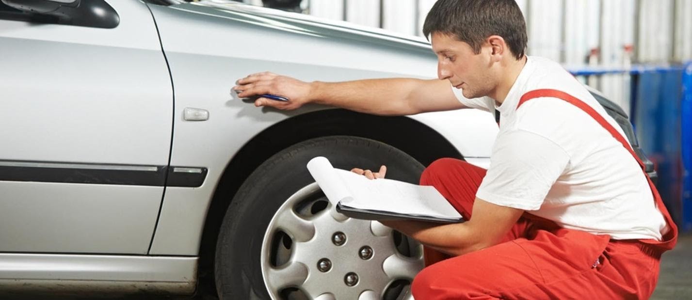 Mechanic inspecting a car’s body