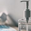 hand sanitiser with surgical masks in the background