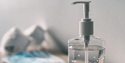 hand sanitiser with surgical masks in the background