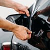A man placing car window tint