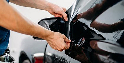 A man placing car window tint