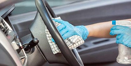 man cleaning the front panel of his car