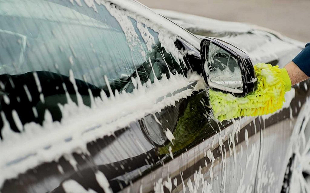 A car drenched with car washing solution and water