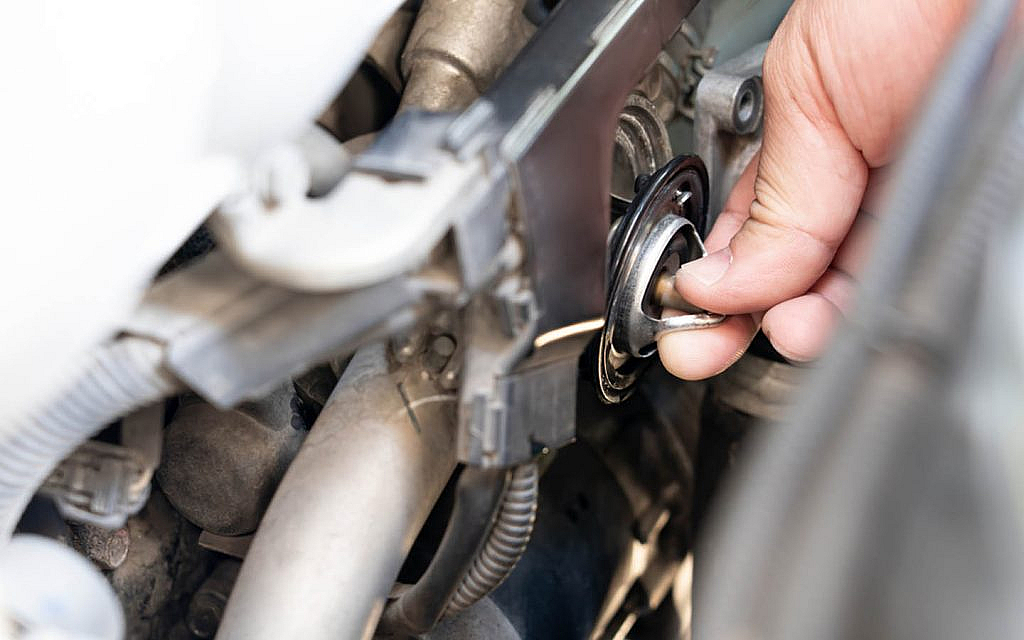 A technician checking car thermostat