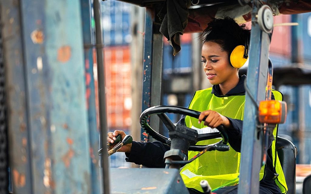 Female driving forklift in an industrial warehouse