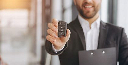 Car dealership representative assisting with car registration renewal in Sharjah