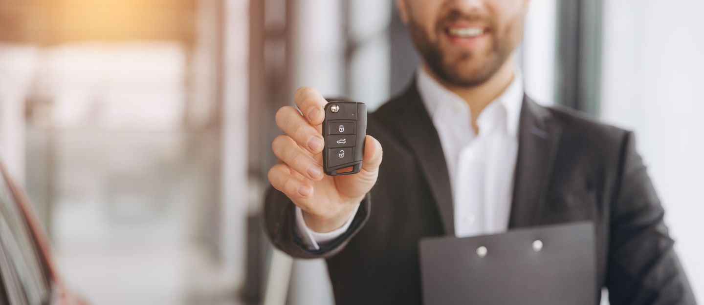 Car dealership representative assisting with car registration renewal in Sharjah