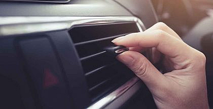 A woman checking the Symptoms of a Bad Blower Motor Resistor