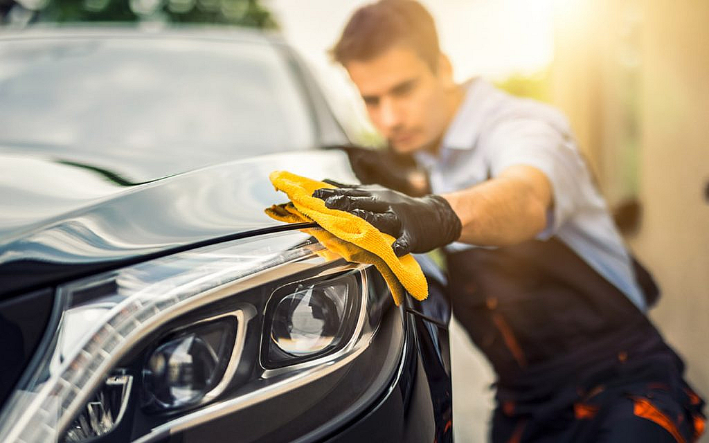 A person waxing a car to give it an expensive look