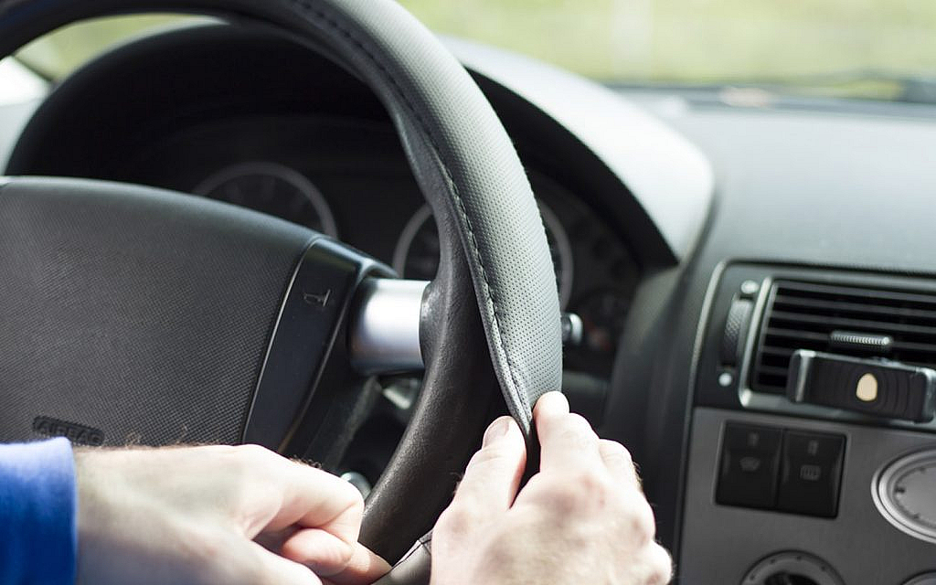 A man changing steering wheel cover to make his car look expensive