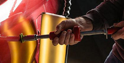 A person is removing the dents
