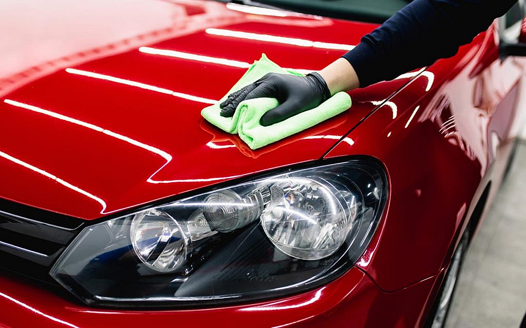 A man cleaning car headlights with cloth