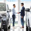 inside view of a car showroom with two man making a deal