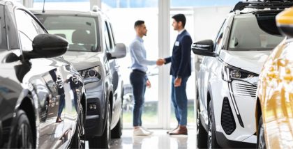 inside view of a car showroom with two man making a deal