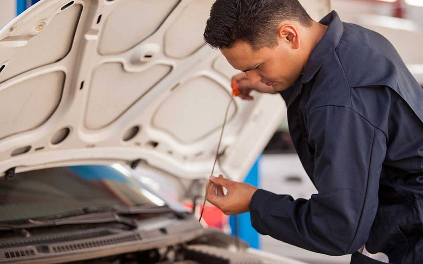 شخص يفحص مستوى زيت السيارة