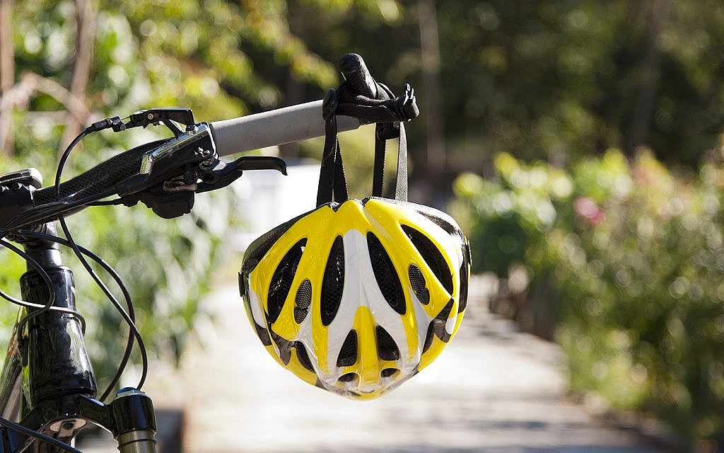  A protective helmet hanging from the steering rod of a cycle