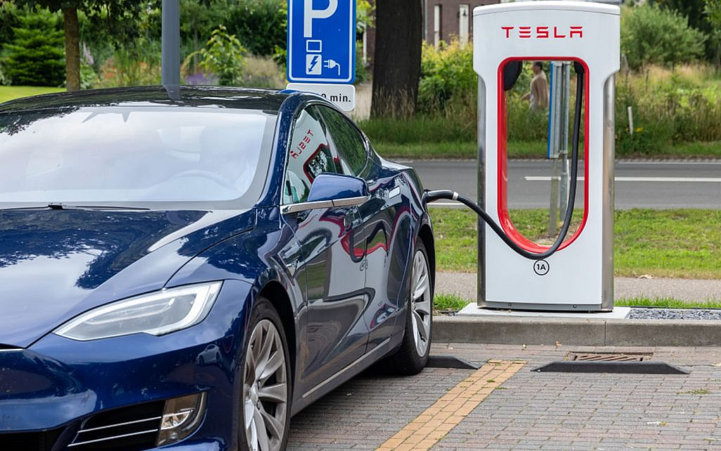 Tesla car being charged at a Tesla supercharger station