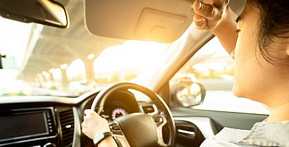 فتاة تواجه الشمس في القيادة