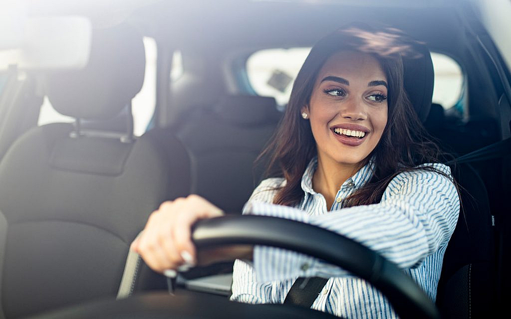 A woman is driving a car with a safety belt